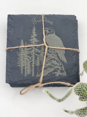Laser-engraved slate coaster set featuring an eagle and forest design
